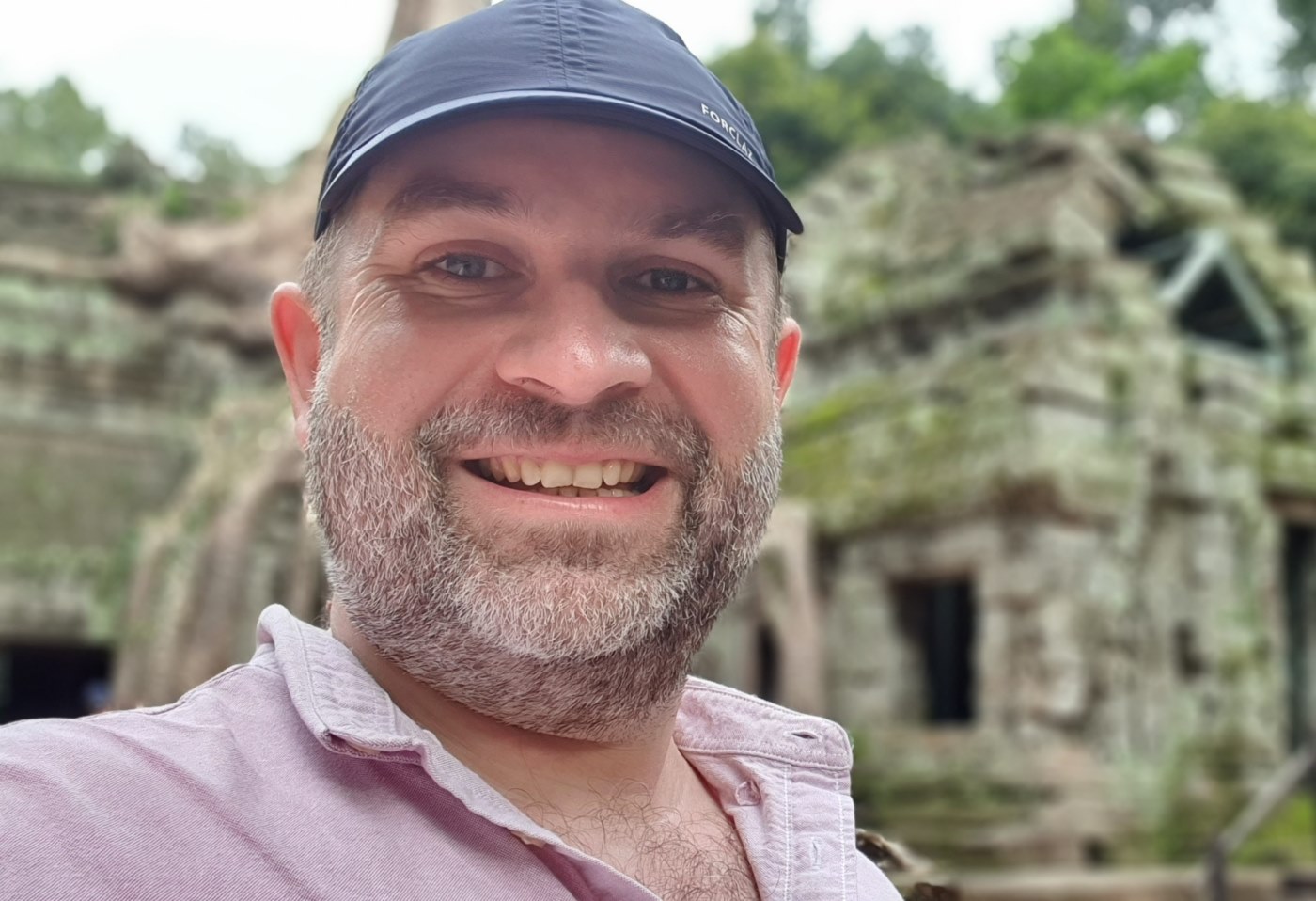 Uśmiechnięty portret w świątyni Ta-Prohm w Angkor, symbolizujący bliskość i autentyczność.