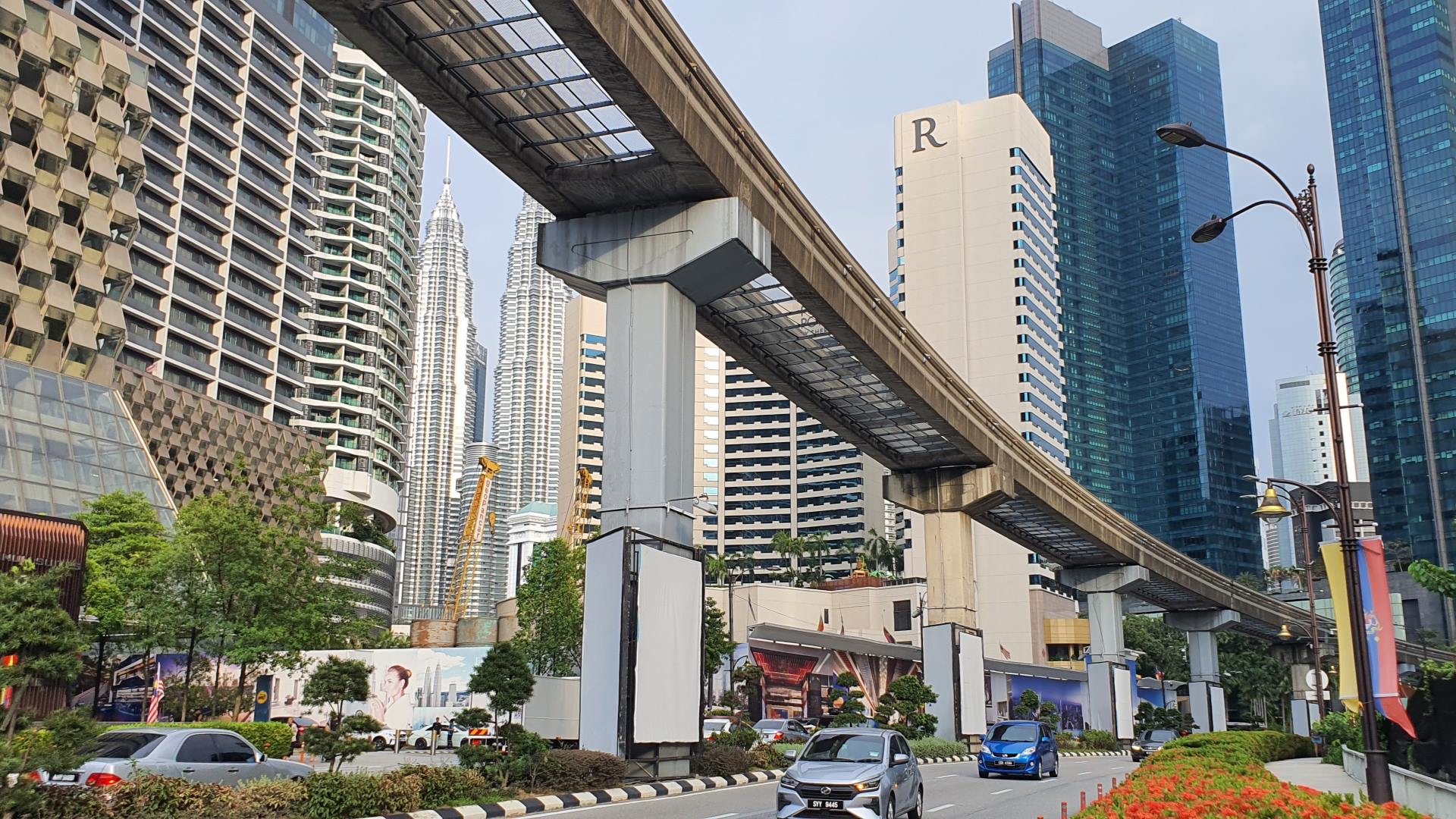 Kuala Lumpur widok z ruchliwej ulicy na podwójny tor Monorail z kilkoma wieżowcami i Petronas Twin Towers w tle