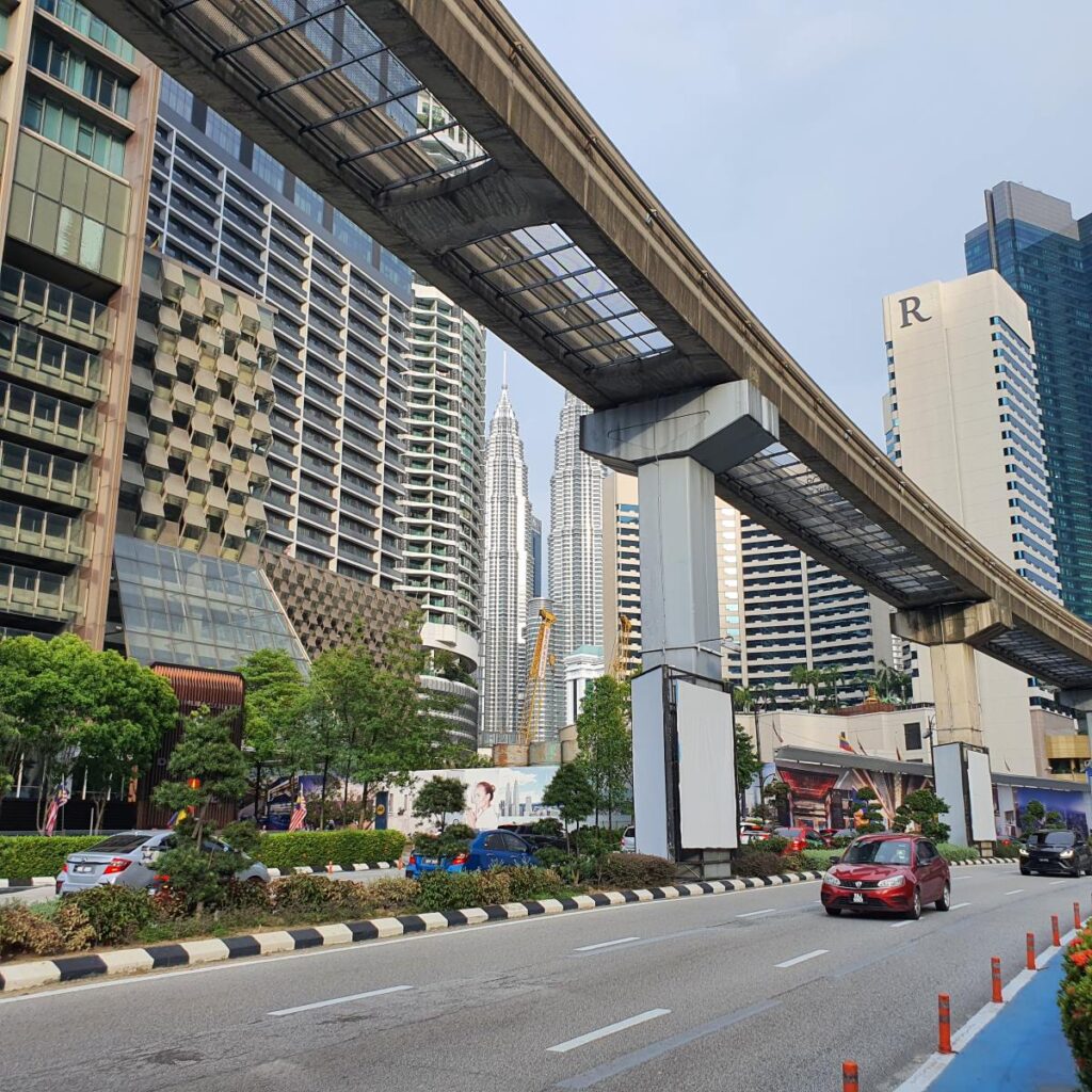 Tor kolejki Monorail nad ulicą miasta w Kuala Lumpur Petronas Twin Towers w tle